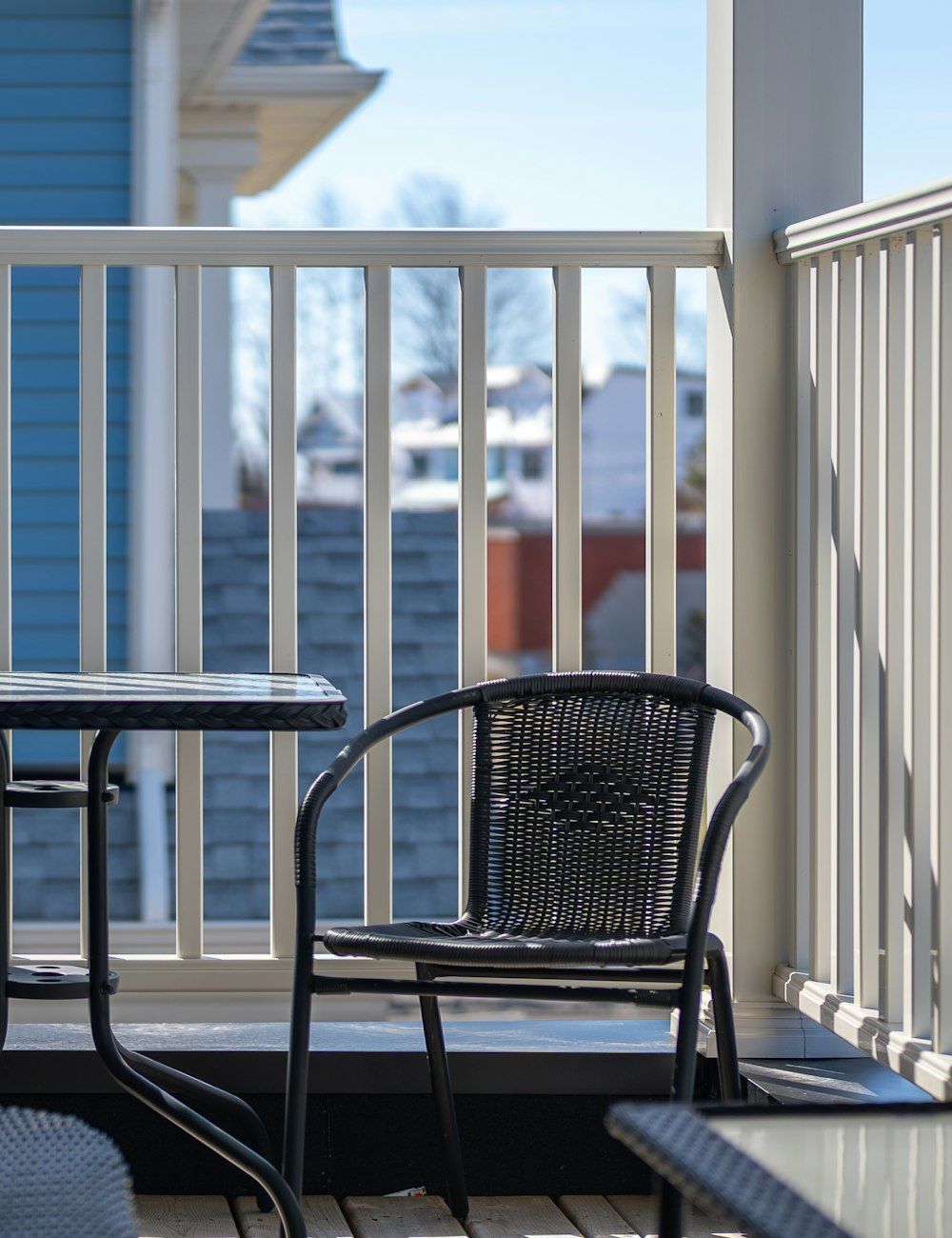 A balcony with a table and chairs looking over the street